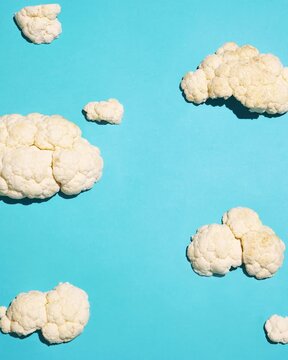 Cauliflower florets resembling clouds on turquoise background