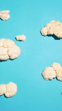 Cauliflower florets resembling clouds on turquoise background