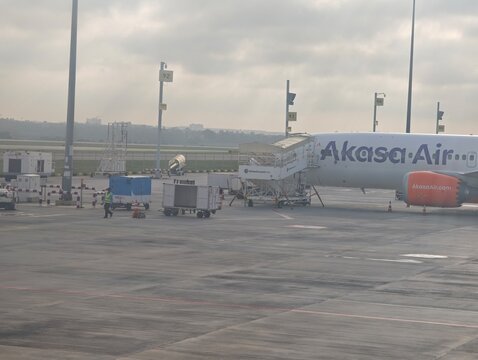 An Akasa Air Boeing 737 Max aircraft parked on the tarmac at Bengaluru International Airport with airport ground handling equipment in the background