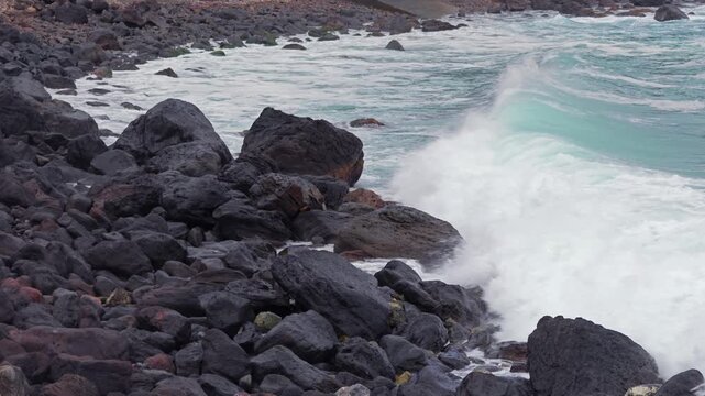 岩場の浜を波が覆い尽くす風景。