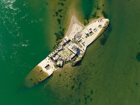 Jarak, Serbia - 14 August 2026: Aerial view of the wreck of the steam tug Slovenac in the Sava River, exposed by extremely low water levels, showing the rusted hull and deck structures.