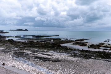 View of underwater oyster farms in Cancale, Brittany, exposed during low tide, raditional sustainable aquaculture and production of premium French oysters, France © barmalini