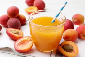 Apricot juice in glass and fresh fruits on white table, closeup © New Africa