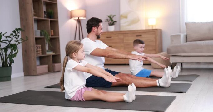 Father and his kids doing exercise together at home