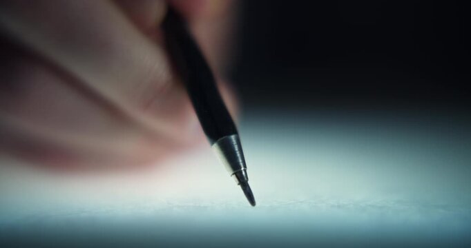 Extreme close-up footage of a man's hand drawing with a mechanical pencil, captured with a shallow depth of field and selective focus. Detailed creative process showing precise pencil drawing