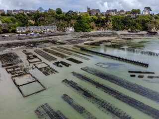 Aerial drone view of underwater oyster farms in Cancale, Brittany, exposed during low tide, raditional sustainable aquaculture and production of premium French oysters, France © barmalini