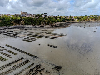 Aerial drone view of underwater oyster farms in Cancale, Brittany, exposed during low tide, raditional sustainable aquaculture and production of premium French oysters, France © barmalini