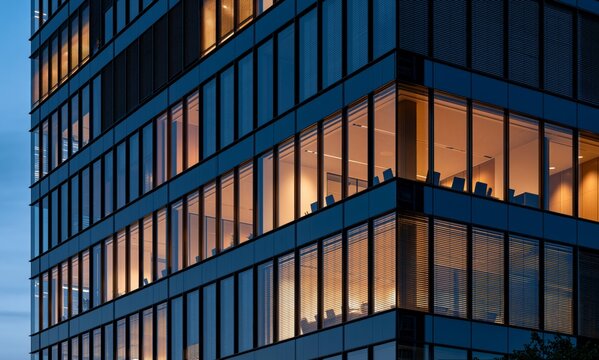 Modern office building facade with illuminated windows in the twilight hour