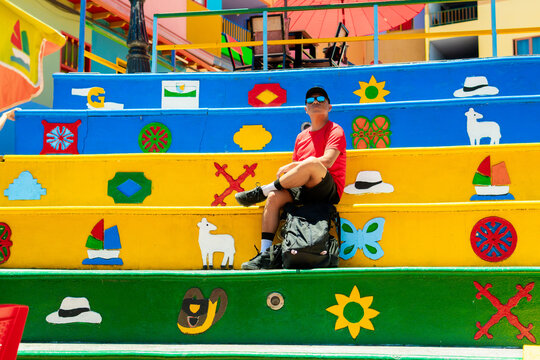 Man relaxing on colorful zocalos in guatape
