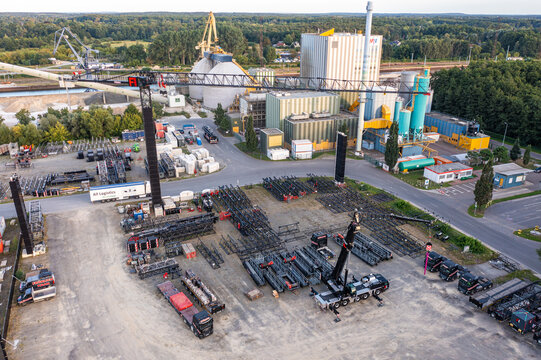 Aerial view of Kran Bau und Baustellenlogistik facility with industrial cranes, heavy machinery, and equipment stored in the yard in Konigs Wusterhausen, Brandenburg, Germany.