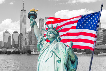 Statue of Liberty with a large american flag and New York skyline in the background © Maria