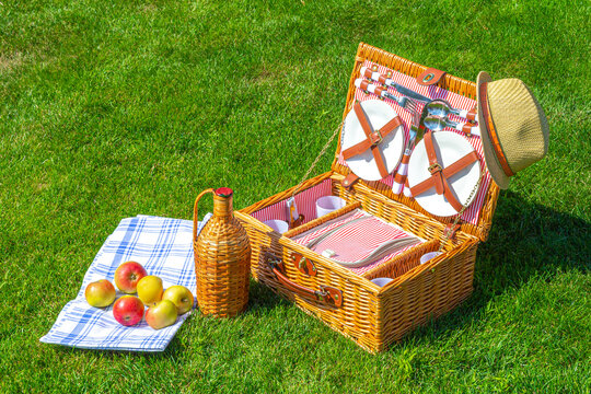 Weekend Picnic straw basket on green sunny lawn in the park