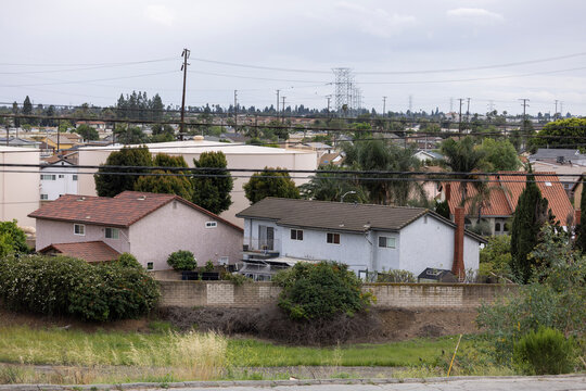 Overcast stormy sky over oil storage and neighborhood homes in Montebello, California, USA.