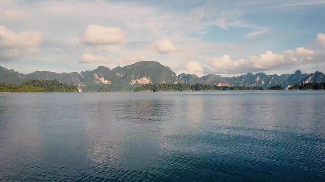 Aerial view of majestic limestone mountains towering over calm lake water in Thailand.