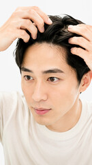 Fototapeta premium 手で髪をかき上げてM字型の生え際を確認する日本人男性