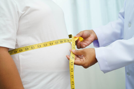 Asian woman with fat belly big size overweight and obesity with measure tape.