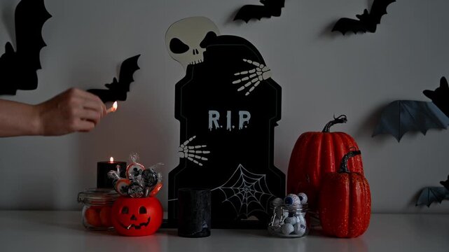 Dark and spooky halloween footage with woman lighting up black candles