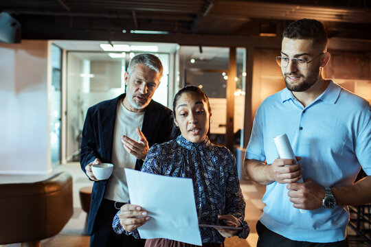 Coworkers reviewing documents during meeting in modern office