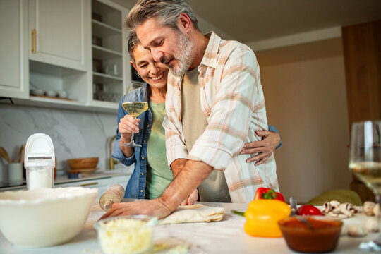Mature couple cooking together in home kitchen