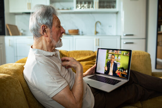Senior man having telehealth video call at home