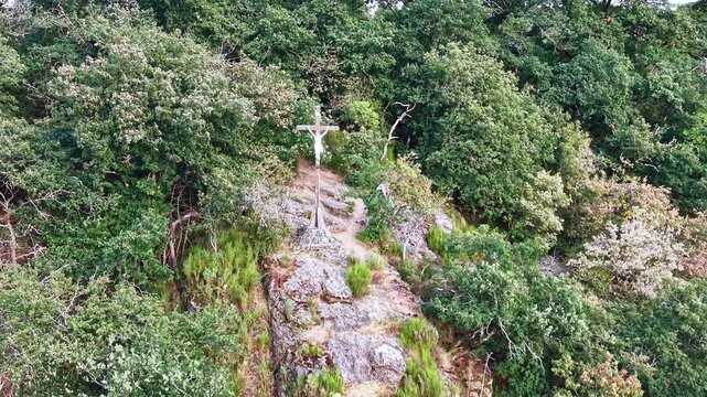 Drone retreats from a rocky forest calvary near Saint Berthevin in France