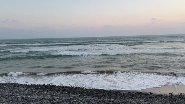 Ocean waves rolling towards the shore at dusk