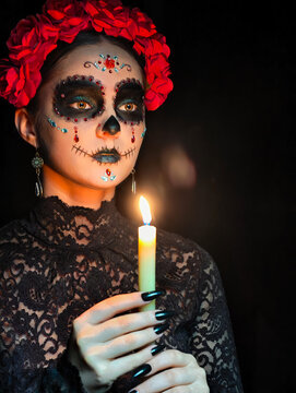 Halloween beauty close-up portrait of woman. Beautiful female face adorned with Santa Muerte makeup.
