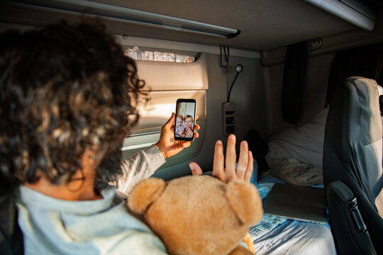 Truck driver video calling family in sleeper cab