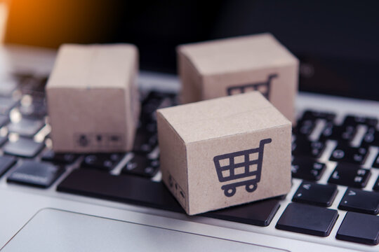 Shopping online. Cardboard box with a shopping cart logo on laptop keyboard. Shopping service on The online web. offers home delivery