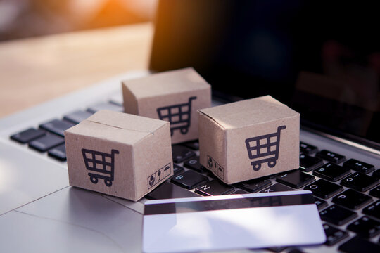 Shopping online. Credit card and cardboard box with a shopping cart logo on laptop keyboard. Shopping service on The online web. offers home delivery
