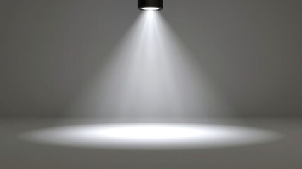 Obraz premium Bright white spotlight shining down from above onto a dark empty floor, creating a cone of light. Ideal for product presentation backgrounds and dramatic exhibition concepts.