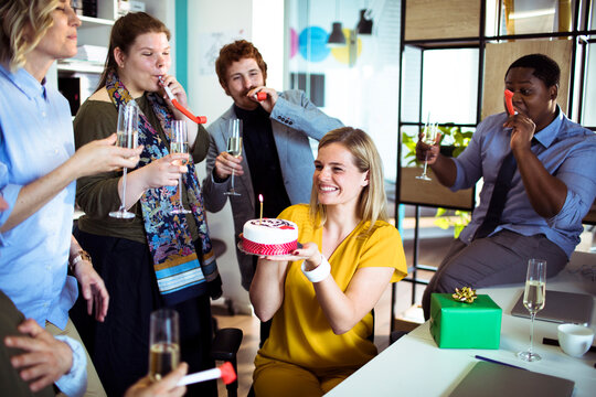 Coworkers celebrating a birthday in modern office