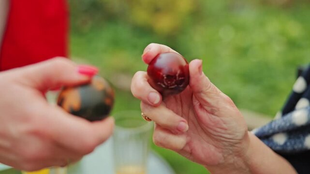 Women tap dyed eggs together, Easter battle testing which shell stays whole