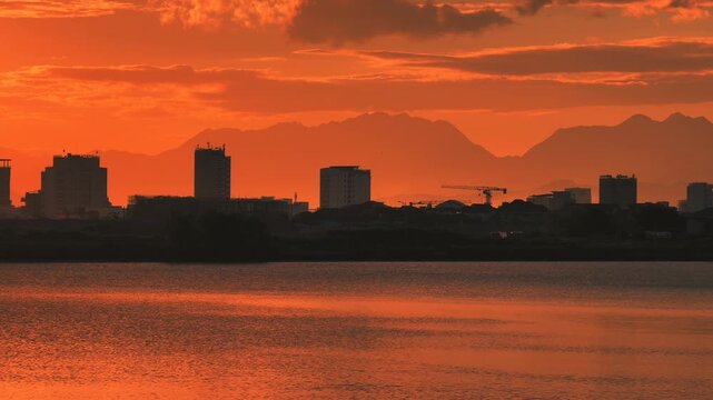 Skyline with coastal city buildings Silhouettes and mountains in the background at Golden Sunset