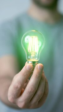 Glowing Light Bulb Held by Hand, ESG Sustainable Energy Efficiency, Environmental Responsibility, Innovation and Sustainable Living Support