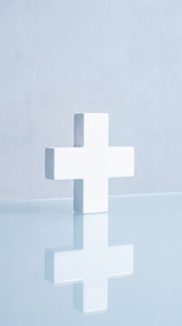 White medical cross symbol on reflective surface represents healthcare insurance and clinical support