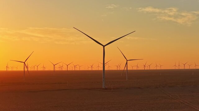 Solar photovoltaic panels at sunrise/sunset; wind turbine power plant; new energy