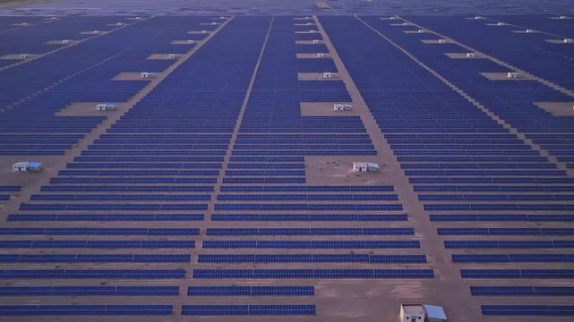 Solar photovoltaic panels at sunrise/sunset; wind turbine power plant; new energy