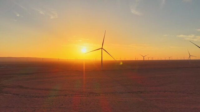 Solar photovoltaic panels at sunrise/sunset; wind turbine power plant; new energy