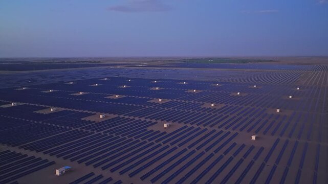 Solar photovoltaic panels at sunrise/sunset; wind turbine power plant; new energy