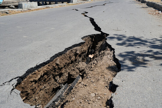 Cracked asphalt road surface after earthquake damage in Marapokot, Flores, Indonesia. Natural disaster concept.