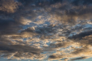 Fototapeta premium Dramatic sky with golden hour clouds and deep blue sky