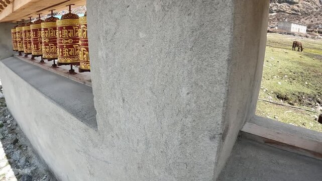 Footage of someone spinning a prayer wheels in Langtang village, Nepal. A prayer wheel is a cylindrical device used in Tibetan Buddhism to spread spiritual blessings and mantras.
