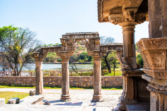 Historic Sahastrabahu or sas bahu Temple Rajasthan, India, lush green trees, a serene lake and clear blue sky in background