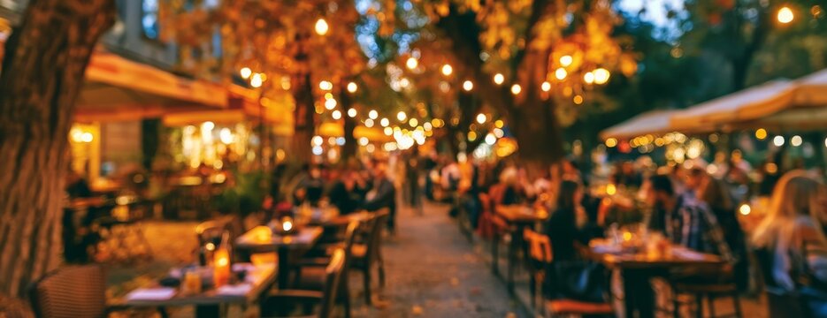 Autumn outdoor caf&eacute; with people dining under string lights, blurred background  