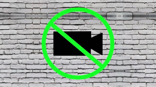 Camera prohibition symbol rendered neatly across a concrete brick wall surface, establishing a clear visual boundary for privacy protection and strict rules against unauthorized video recording.