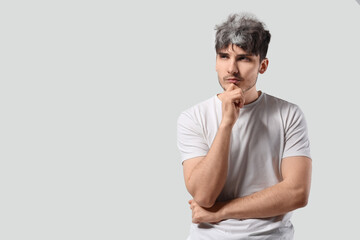 Fototapeta premium Thoughtful young man with graying hair on white background