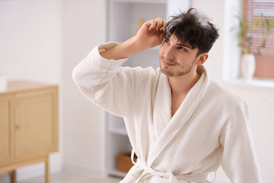 Young man with graying hair in bathroom