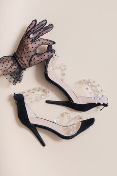 High-heeled shoes with clear straps and decorative stones on light background