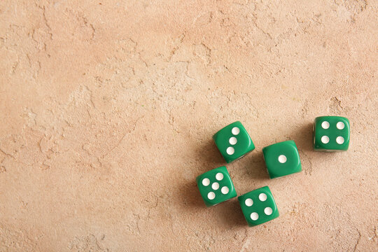 Green dices on beige background
